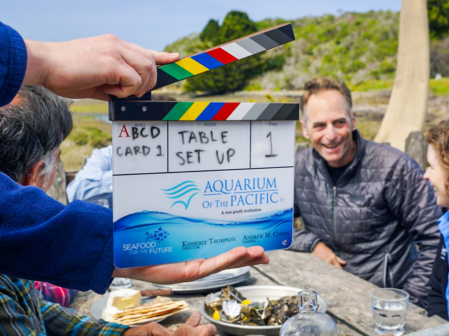 Film clapper and people sitting at table